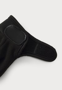 Gant de poils noir avec une sangle en velcro texturée et des bords lisses, conçu pour un ajustement sécurisé et une chaleur optimale.