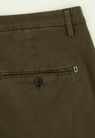 Khaki chinos featuring a smooth texture, a back pocket with a button closure, and a small metal logo accent near the pocket.