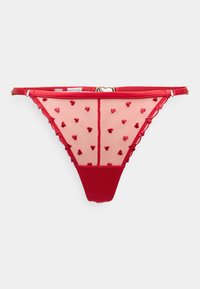 Tanga rouge en tissu en maille transparente avec de petits motifs en forme de cœur et des bordures festonnées. Dos rouge uni pour le contraste. Matériel de taille ajustable.