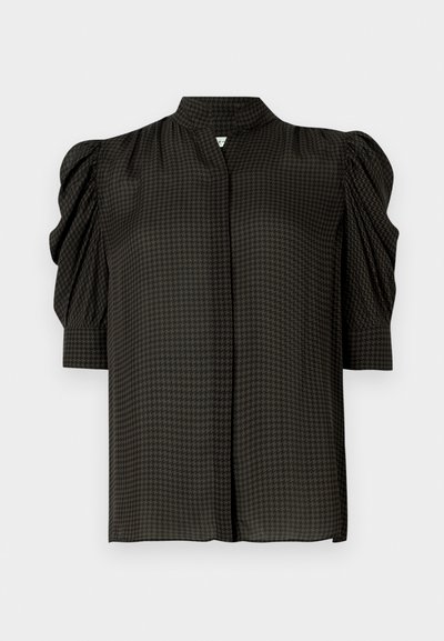 Mustast lühikeste varrukatega pluus, millel on püstkrae, tekstuuriga hundhammasmuster ja padjandatud õlad. Pehme kangas, lõdvestunud lõige.