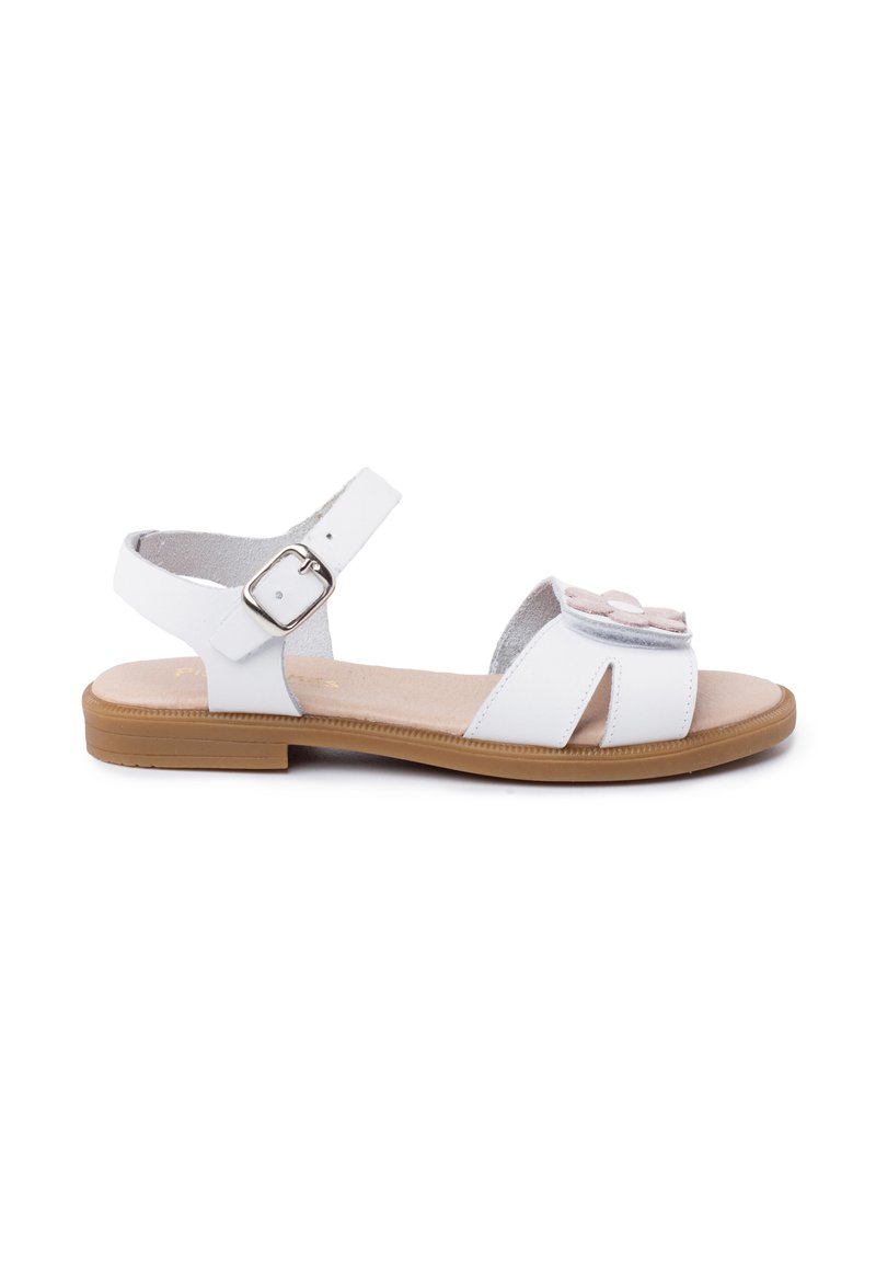 White sandal made of synthetic material, featuring a simple design with an adjustable ankle strap, floral accent, and a tan outsole.