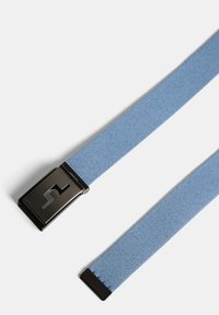 Blå tygbälte med en slät textur, som har en rektangulär svart metallspänne med ett uthugget mönster. Bältets ändar är färdiga.