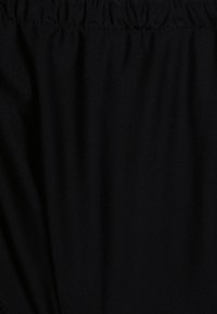 Tecido preto com uma superfície lisa e texturizada, apresentando detalhes franzidos ao longo da borda superior. Sem padrões ou ferragens distintas visíveis.