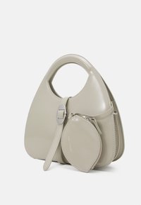 Beżowa torebka owalnego kształtu wykonana z błyszczącej skóry, z uchwytem i odłączaną małą kieszonką. Posiada srebrne okucia i detale ze szwem.