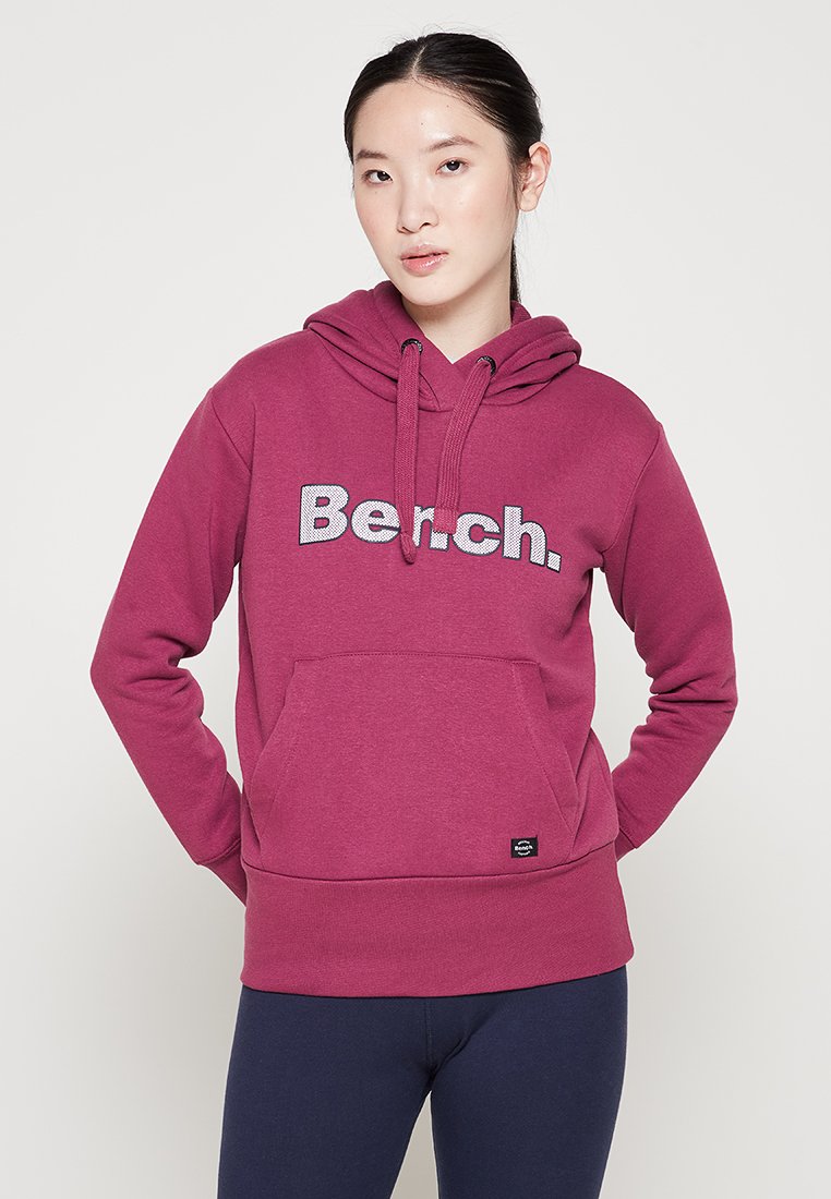 Bordeauxfarbener Kapuzenpullover mit einer frontalen Tasche und dem auffälligen, silbernen "Bench."-Logo. Hergestellt aus weichem Material; mit Kordelzugkapuze und gerippten Bündchen.