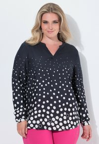 Camicia a maniche lunghe in tessuto nero con un motivo a gradient di pois bianchi. Design a V con vestibilità ampia e tessuto morbido.