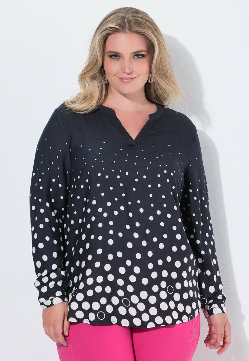 Camicia a maniche lunghe in tessuto nero con un motivo a gradient di pois bianchi. Design a V con vestibilità ampia e tessuto morbido.