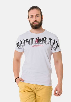 Weißes Baumwoll-T-Shirt mit auffälligem schwarzen Grafiktext und einem roten Totenkopf-Motiv auf der Vorderseite. Kurze Ärmel und ein runder Halsausschnitt.