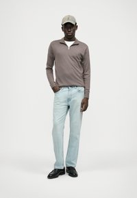 Heled pruun zip-neki kampsun, helesinised sirged teksad ja mustad nahksandaalid. Hõbehall müts rõhutab lõppkokkuvõttes kaunist ja vabamat ilmet.