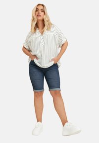 Raidalliset lyhythihaiset puserot valkoisena ja mustana, yhdistetty tummaan siniseen farkkushortsiin, käännetyt reunat, ja valkoiset tennarit. Rentoa asua.