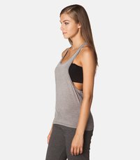 Grå tanktopp med vide ermer og løs passform, laget av mykt materiale, kombinert med en svart sport-BH under.