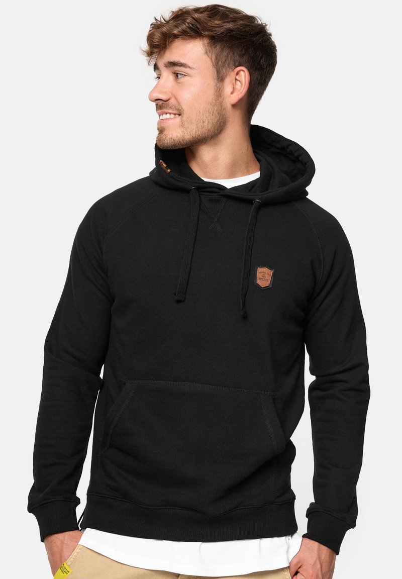 Zwarte hoodie met een voorkant zak, textuurstof, ribbelmanchetten en onderrand, met een klein bruin logo-opdruk op de borst.