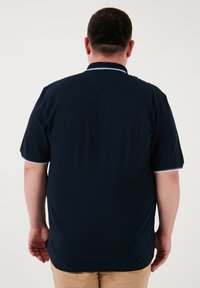 Námornícky polokošeľa s krátkym rukávom má jednofarebný dizajn, kontrastný lem goliera a rovný lem. Textúrovaná látka s hladkým povrchom.