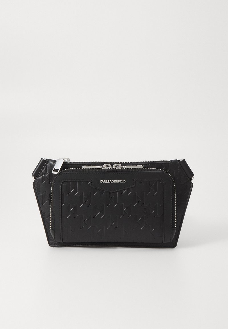 Borsa a mano in pelle nera con motivo geometrico testurizzato, dotata di un compartimento con zip e dettagli in metallo argentato. Design compatto e angolare.