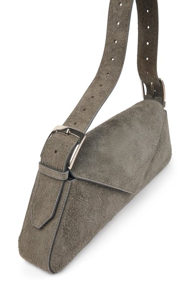 Borsa a tracolla grigia in suede con tracolla regolabile, dotata di più fori e una fibbia argentata, su sfondo bianco.