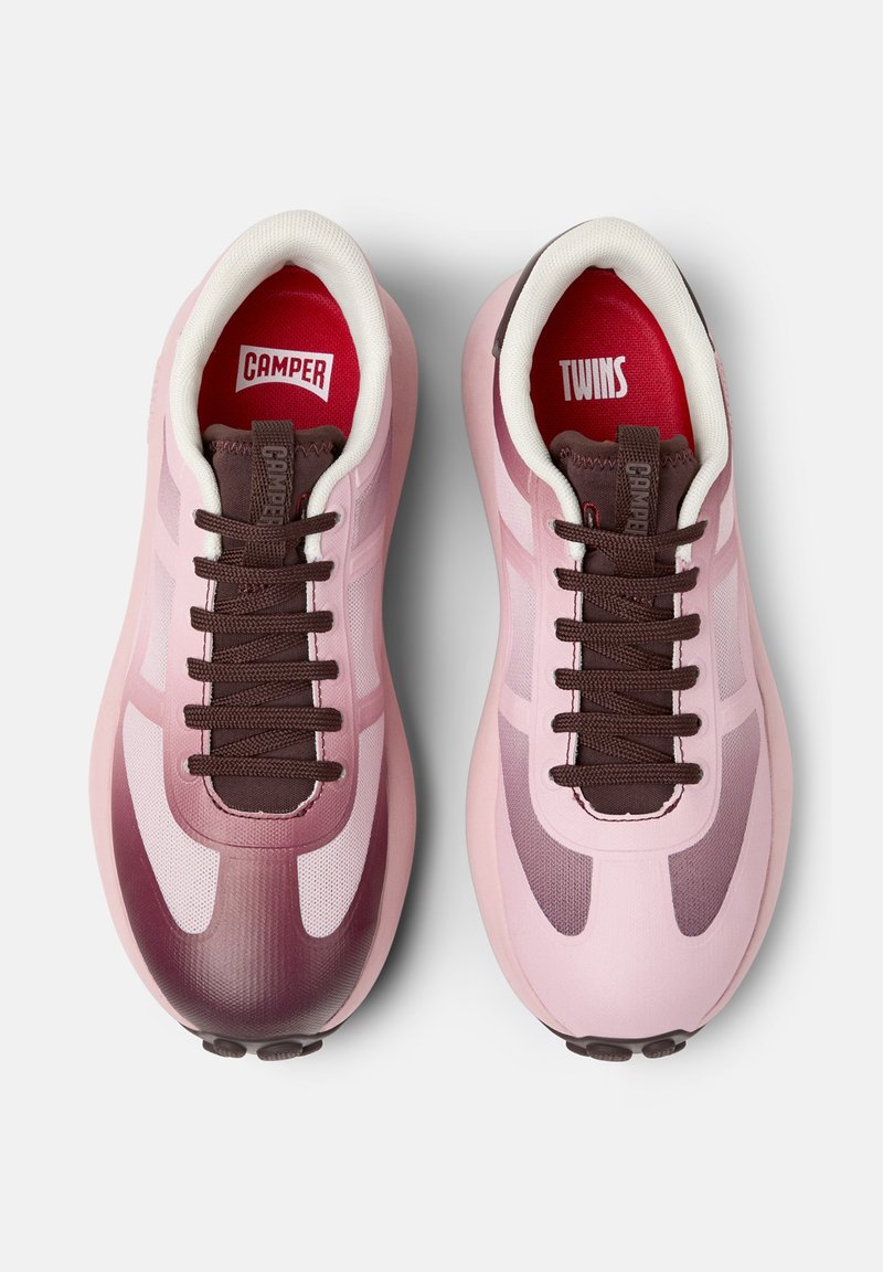 Sportliche rosa Turnschuhe mit braunen Schnürsenkeln und Branding an der inneren Zunge, die ein Farbverlauf-Design und eine moderne Silhouette aufweisen.