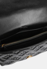 Borsa a mano in pelle nera con motivo a logo in rilievo, hardware dorato, scomparto con zip e superficie liscia. Interno foderato in nero.