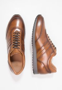 Braune Leder Schuhe mit glatter Oberfläche, ausgestattet mit drei horizontalen Streifen, abgerundeter Zehenpartie und einer strukturierten Gummisohle mit Schnürsenkeln.