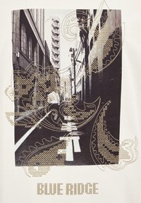 Graphic T-shirt featuring a black and white urban photograph with gold paisley patterns and "BLUE RIDGE" text in block letters at the bottom.