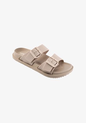 Beige muiltje met twee verstelbare gespen en een gestructureerde zool voor grip, ontworpen voor vrijetijdsgebruik.