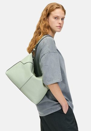 Sac à épaule en cuir vert clair, avec une forme structurée et des accents noirs, doté d'une fermeture éclair et d'une large sangle pour le transport.