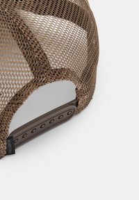 Brown mesh cap with a structured crown and adjustable plastic strap, featuring a subtle logo tag for identification.
