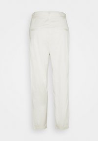 Pantalon droit beige clair en coton, doté de deux poches arrière et d'une texture lisse, avec une conception de taille simple.