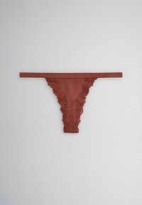 Brown lace-trimmed thong underwear with narrow waistband, laid flat on a gray surface.