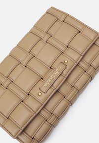 Clutch in pelle beige con design intrecciato, caratterizzato da una placca logo in tonalità oro e dettagli a borchie. Texture liscia e forma rettangolare.