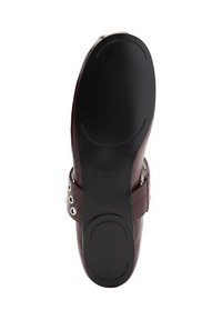 Burgundy nahkaisten kenkien pohja, jossa on sileä musta pohja, pyöristetty korko ja koristeelliset metalliset yksityiskohdat sivuilla.