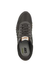 Zapatilla gris con parte superior de malla, acentos de gamuza, punta redondeada y cordones planos. Presenta un logo naranja en la lengüeta y una plantilla acolchada.