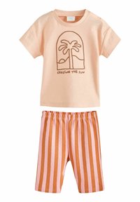 Vaatetus voor peuters met een licht perzikkleurig shirt met korte mouwen, versierd met bruine palmboomborduursels, en bijpassende gestreepte shorts in roze en oranje.