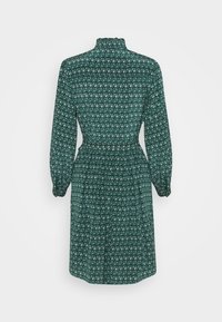 Robe à manches longues vert foncé avec un petit motif floral blanc, col montant et taille froncée, vue de dos.