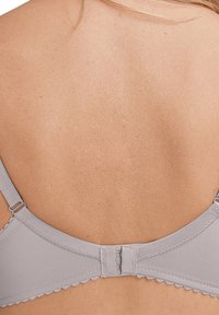 Szary stanik z gładkiego materiału, z falbaniastym wykończeniem, regulowanymi ramiączkami i zapięciem na haftkę z tyłu.