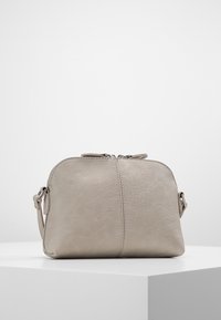 Borsa in pelle grigio chiaro con forma arrotondata, chiusura a doppia cerniera e tracolla staccabile. Texture liscia con dettagli di cucitura minimi.