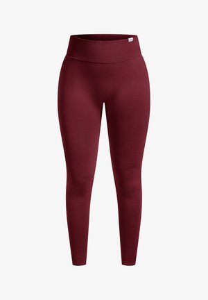 Leggings bordeaux con una larga vita a coste, tessuto liscio e elastico e gambe affusolate. Nessun motivo o accessorio visibile.
