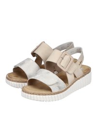 Beiga sandaler med ett metalliskt silverrem, stort spänne och texturerad fotbädd. Vit gummisula med flätad juteinslag. Öppen design.