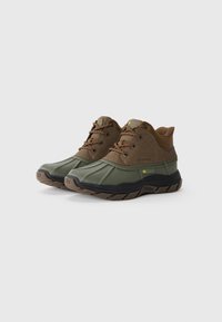 Botas de senderismo impermeables con parte superior sintética marrón y capuchón de goma verde. Suela texturizada para agarre y detalles de costura reforzada.