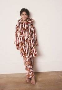 Accappatoio in pile a righe rosse e bianche con motivi di omini di pan di zenzero, pantaloni coordinati e cappuccio; tessuto morbido e cintura in vita.