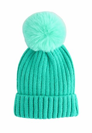 Bonnet en tricot côtelé turquoise avec un large revers et un grand pompon en fourrure sur le dessus, isolé sur un fond blanc.