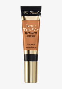 Too Faced Born This Way Soft Matte Oil Control Foundation in a tube with a bronze body, gold accents, and black cap. 24-hour wear claim.