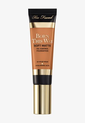 Too Faced Born This Way Soft Matte Öl-Kontroll-Foundation in einer Tube mit bronzefarbenem Körper, goldenen Akzenten und schwarzem Deckel. 24-Stunden-Tragegarantie.