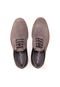 Chaussures en daim gris avec un bout arrondi, un design à lacets et une semelle en caoutchouc marron contrastante. Logo imprimé en or sur la semelle intérieure.