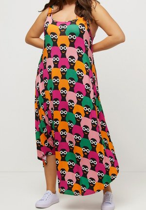 Luźna, bezrękawnikowa sukienka midi z kolorowym, abstrakcyjnym wzorem twarzy w okularach, noszona z białymi trampkami.