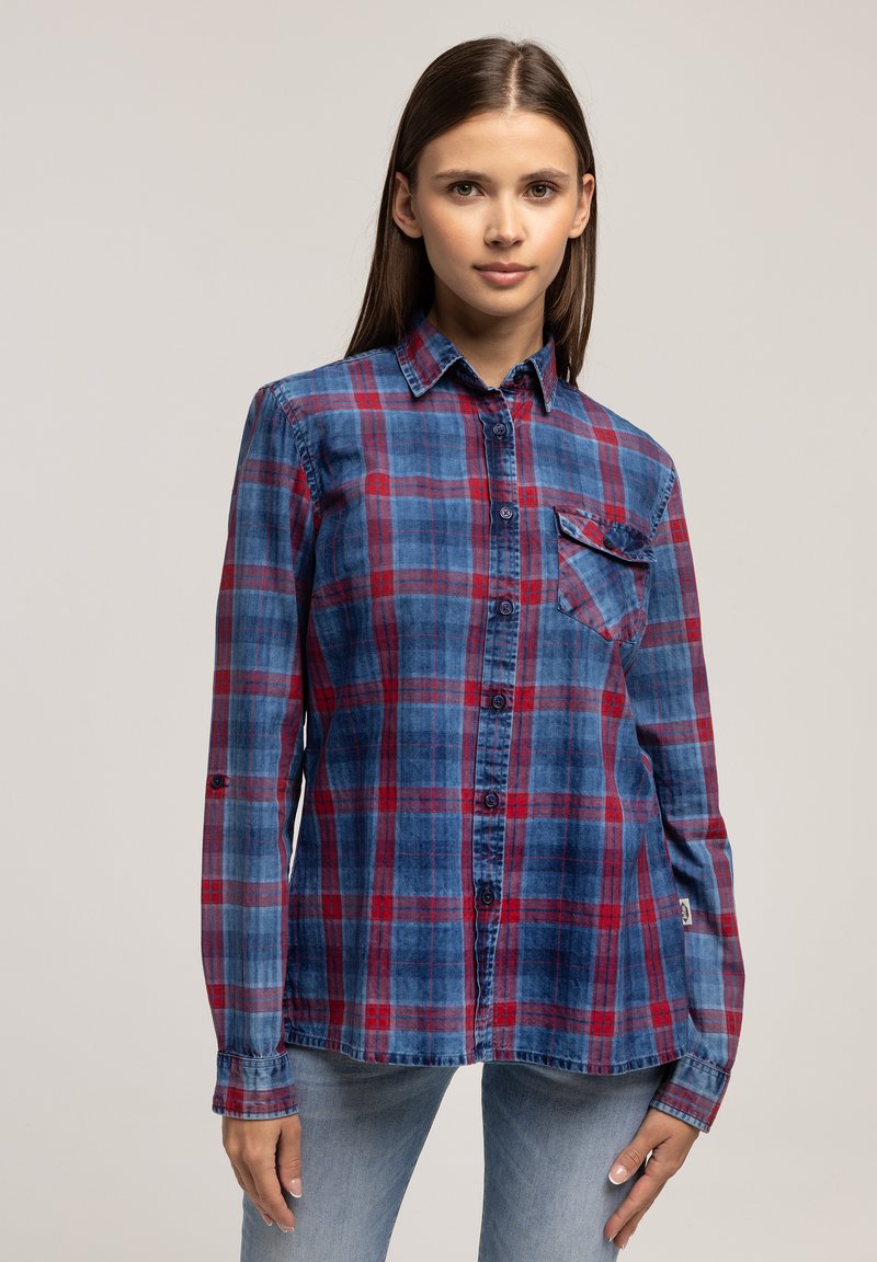 Niebieska i czerwona koszula w kratę z długim rękawem, wykonana z miękkiego materiału. Posiada zapięcie na guziki, kołnierz oraz kieszeń na lewej piersi.
