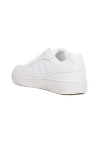 Sneakers bianchi in pelle liscia con suola in gomma testurizzata. Le caratteristiche includono punta rotonda, chiusura con lacci e dettagli perforati.