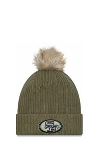 Olivgrüner gestrickter Beanie mit umgeschlagenem Bund und einer tanfarbenen Kunstfell-Pompon oben. Mit einem gestickten Logopatch auf der Vorderseite.