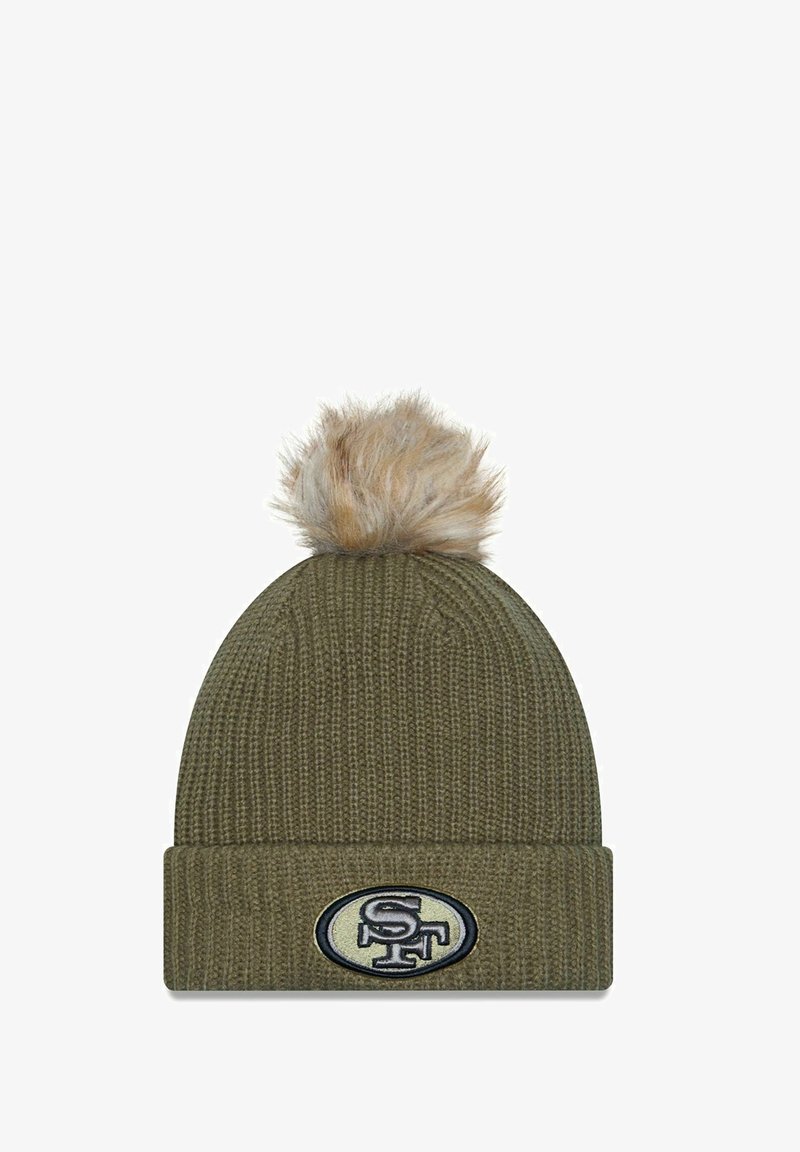 Olivgrüner gestrickter Beanie mit umgeschlagenem Bund und einer tanfarbenen Kunstfell-Pompon oben. Mit einem gestickten Logopatch auf der Vorderseite.