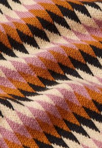 Tissu tricoté avec un motif en diamant dans des nuances de rose, orange, noir et crème. La texture est douce avec un léger stretch.