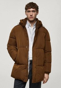 Brown puffer jacket with a hood, featuring a quilted design, snap buttons, and two front pockets. Warm, padded material, medium length.